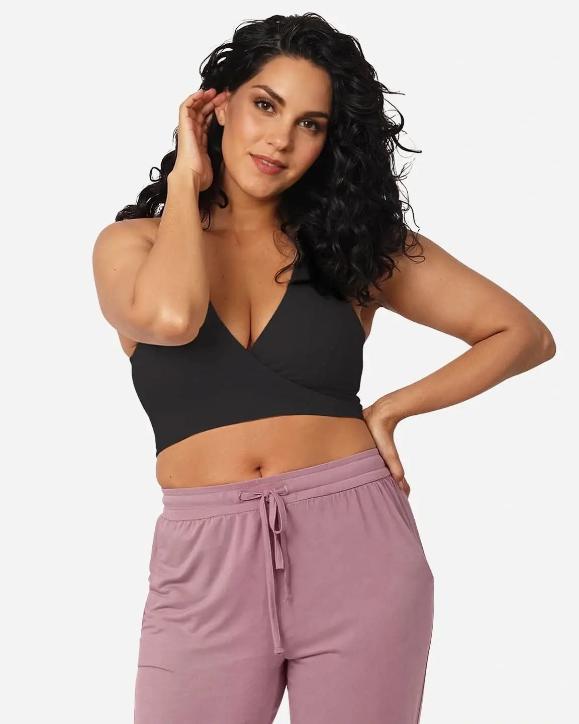 Woman in a black wire-free cotton nursing bra with a wrap front, paired with pink drawstring pants.