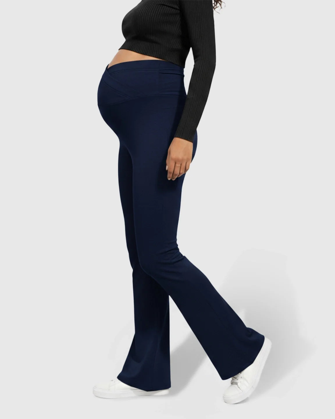 Navy Bump Society flared maternity pants with a crossed waistband, worn by a pregnant woman.