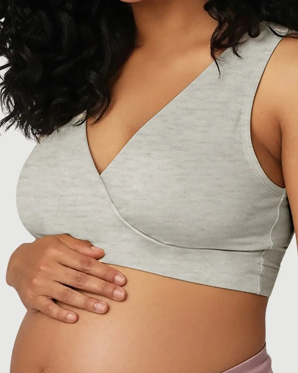 Pregnant woman wearing a light grey soft cotton wire-free nursing bra with a crossover design.