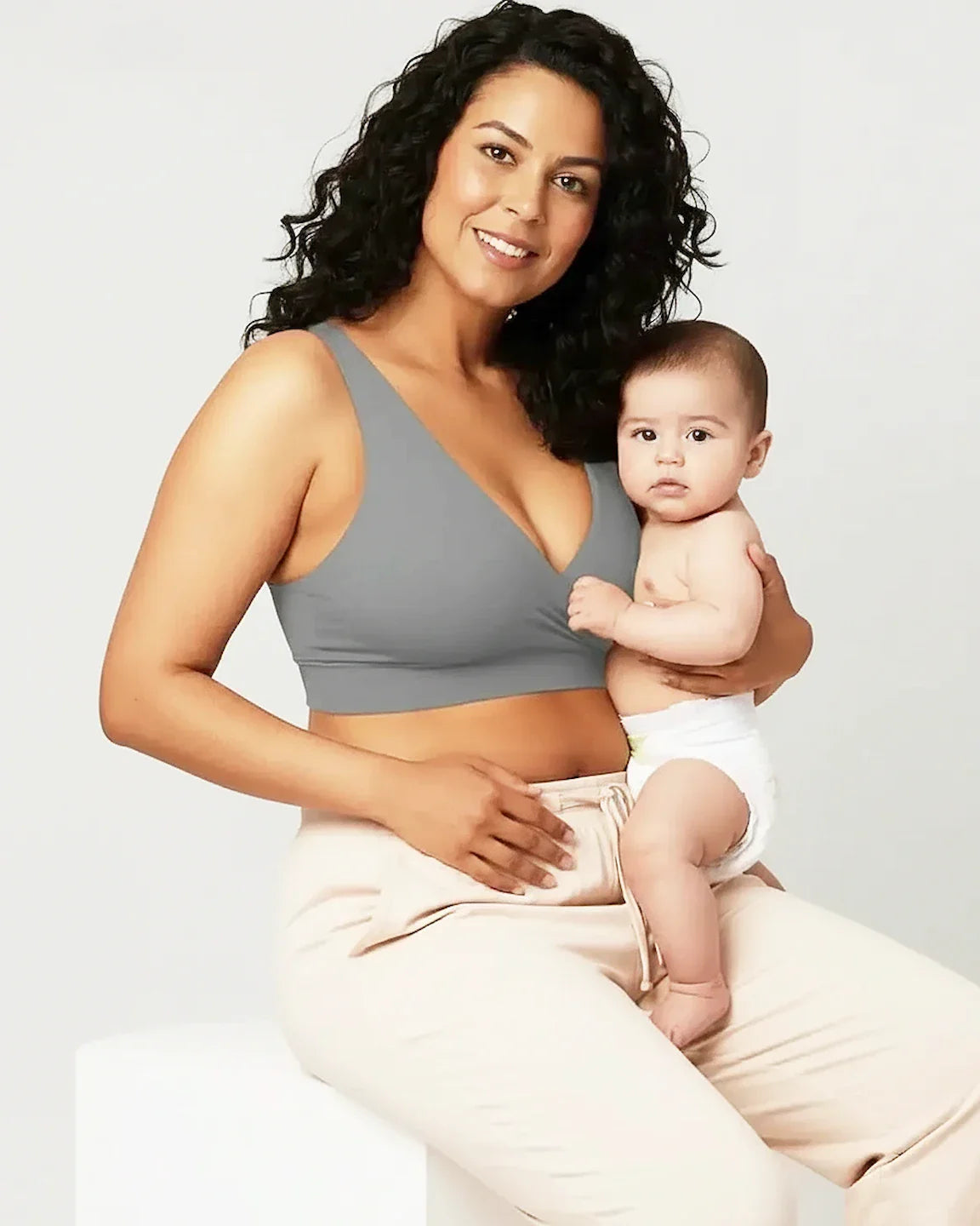 Smiling mother in a gray soft cotton wire-free nursing bra holding her baby.
