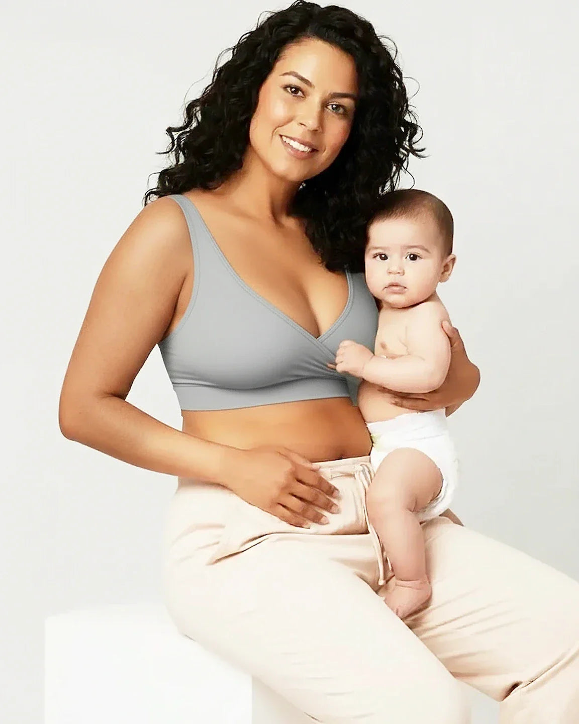 Smiling mother in a gray soft cotton wire-free nursing bra holding her baby.