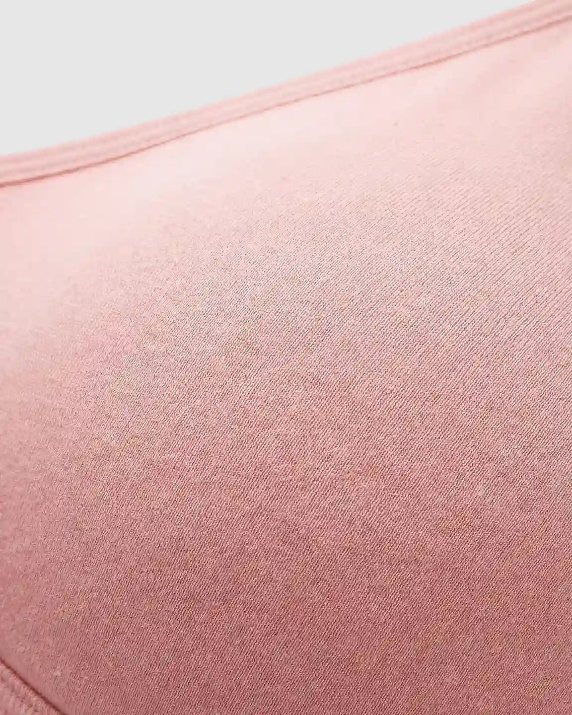 Close-up of a soft, seamless pink wireless nursing bra with a smooth, stretch-infused nylon fabric.