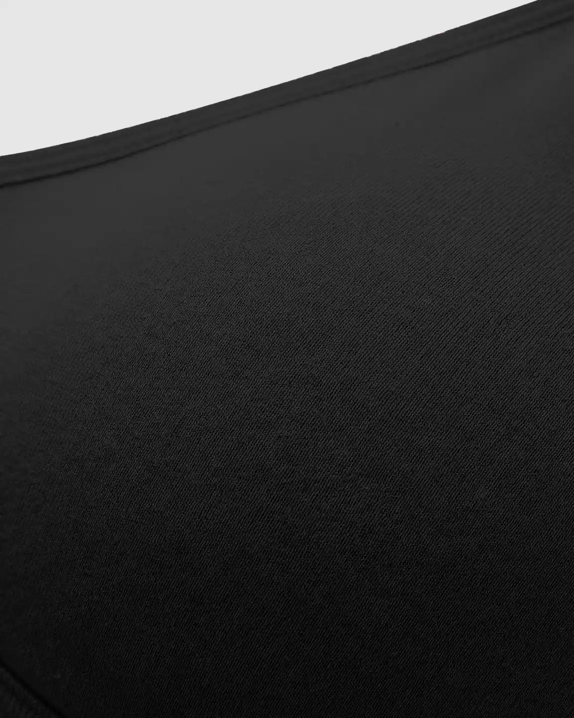 Close-up of a black seamless cross-front wireless nursing bra, showing its soft, stretch-infused nylon fabric.