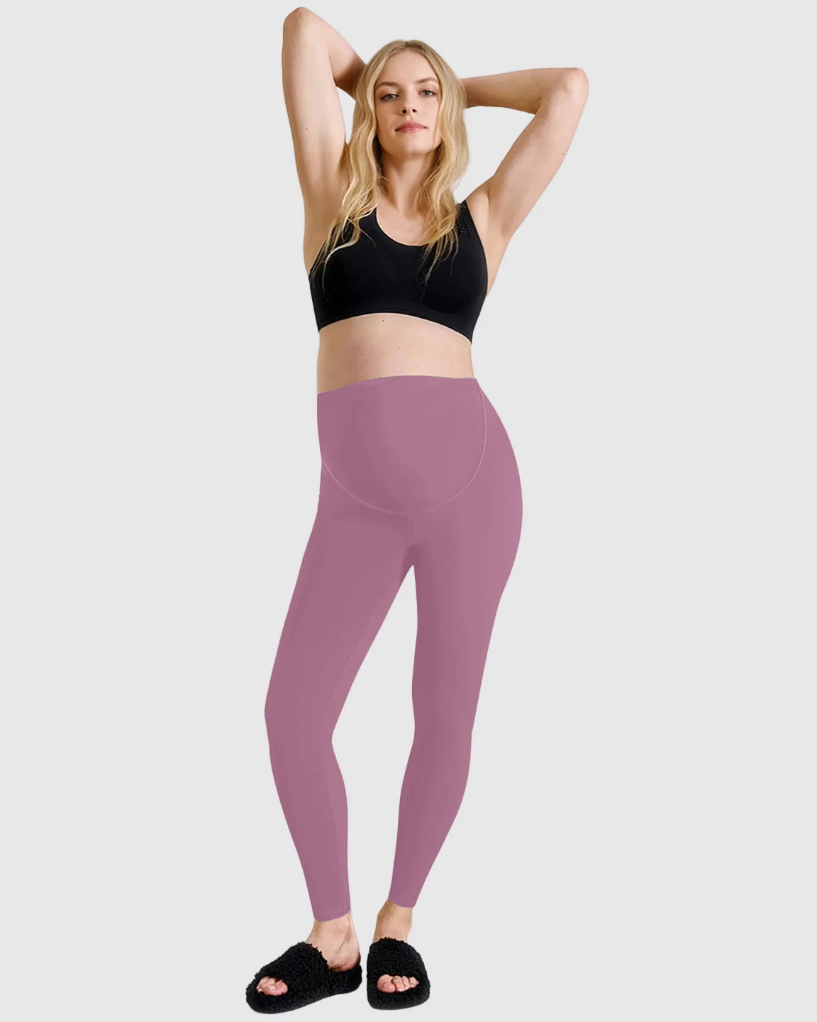 Woman in Bump Society's mauve high-waist belly-support sculpting maternity leggings and a black sports bra.