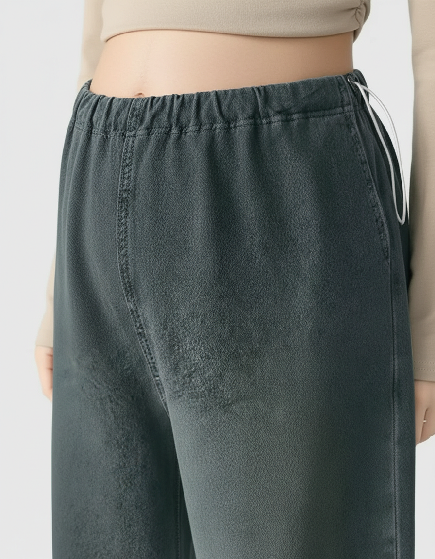 Close-up of dark gray wide-leg maternity denim pants with an adjustable elastic waist and white drawstrings.
