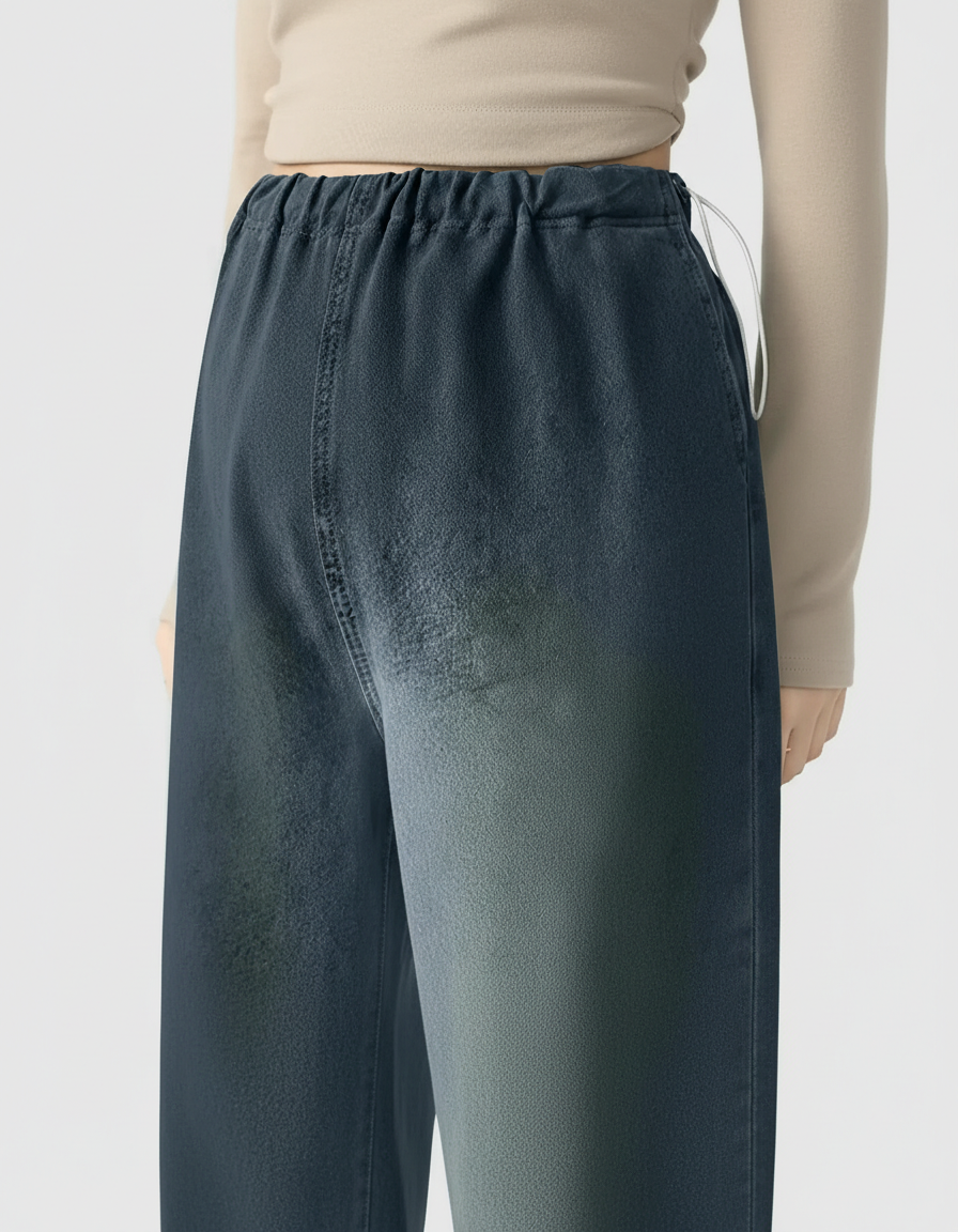Woman wearing dark wash wide-leg maternity denim pants with an adjustable elastic waist.