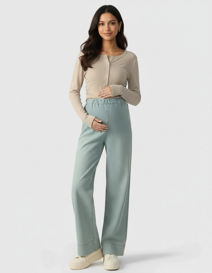 Pregnant woman in light blue wide-leg maternity denim pants and a beige long-sleeve top.