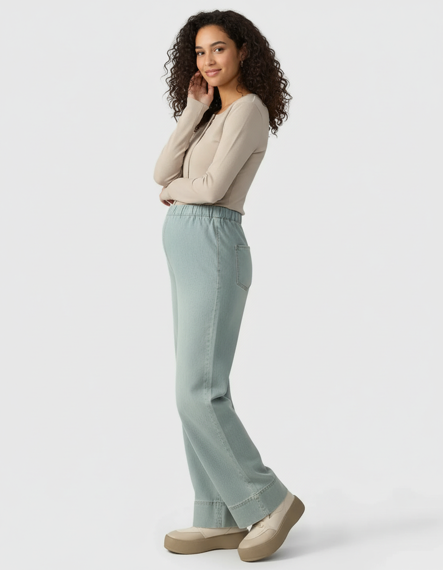 Smiling pregnant woman in light wash wide-leg maternity denim pants with an adjustable waist.