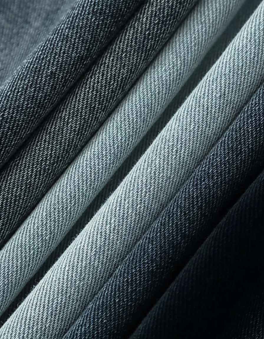 Close-up of folded maternity denim pants in varying shades of blue, showcasing the fabric texture.