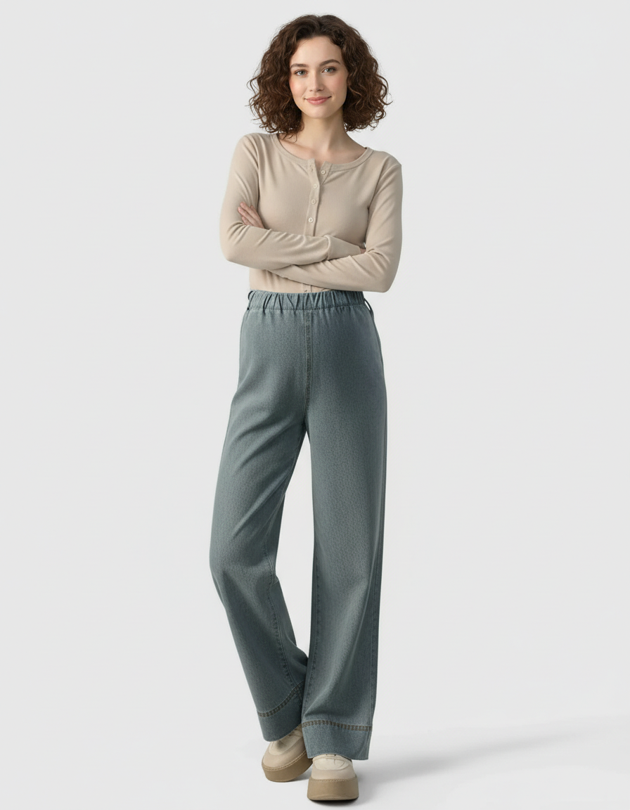 Smiling woman in light wash wide-leg maternity denim pants with an adjustable waist.