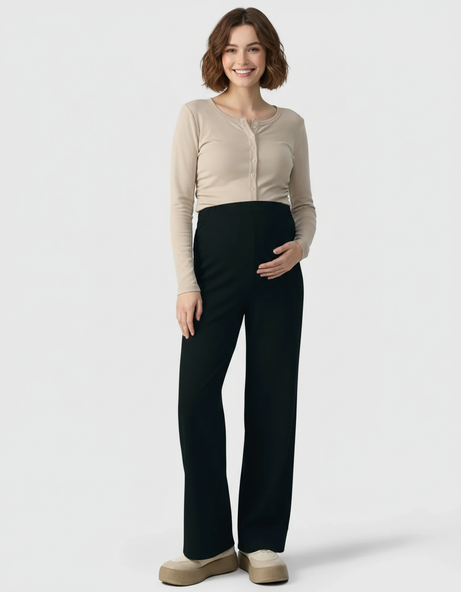 Smiling pregnant woman wearing black wide-leg maternity pants with an adjustable waist and a beige long-sleeve top.