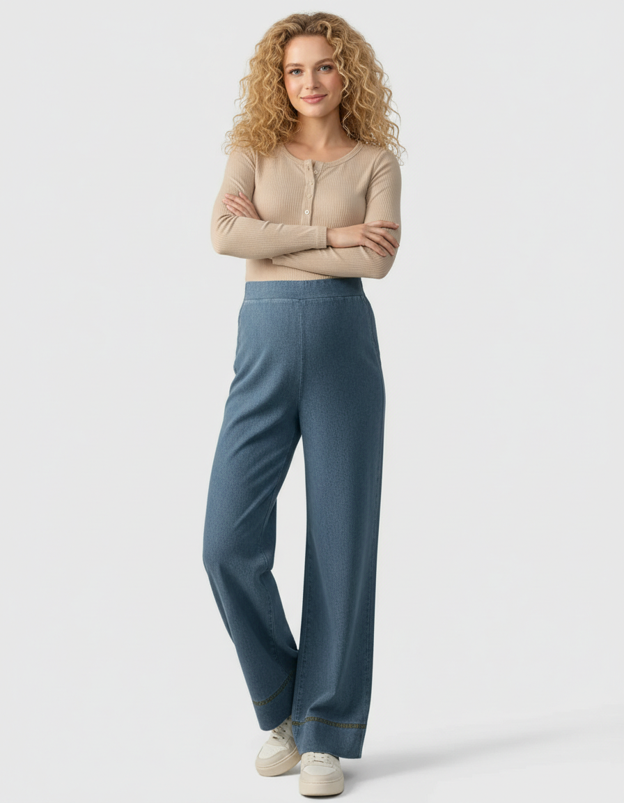 Woman in blue wide-leg maternity denim pants with an adjustable waist and a beige ribbed top.