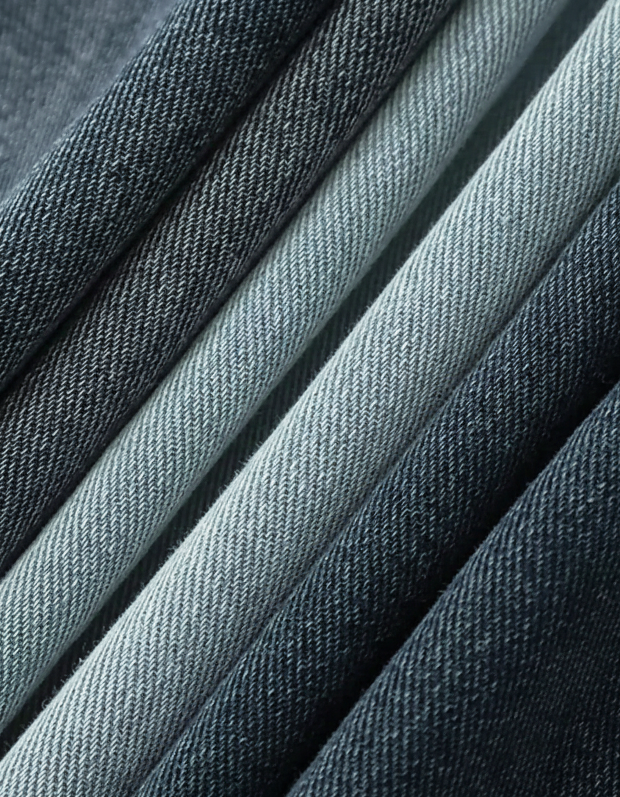 Close-up of folded dark and light blue denim fabric with visible weave texture.