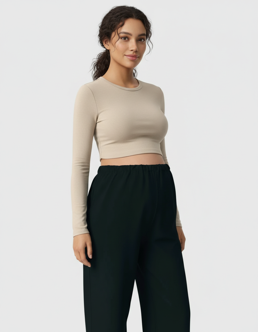Pregnant woman in a beige long-sleeve crop top and black wide-leg maternity pants.