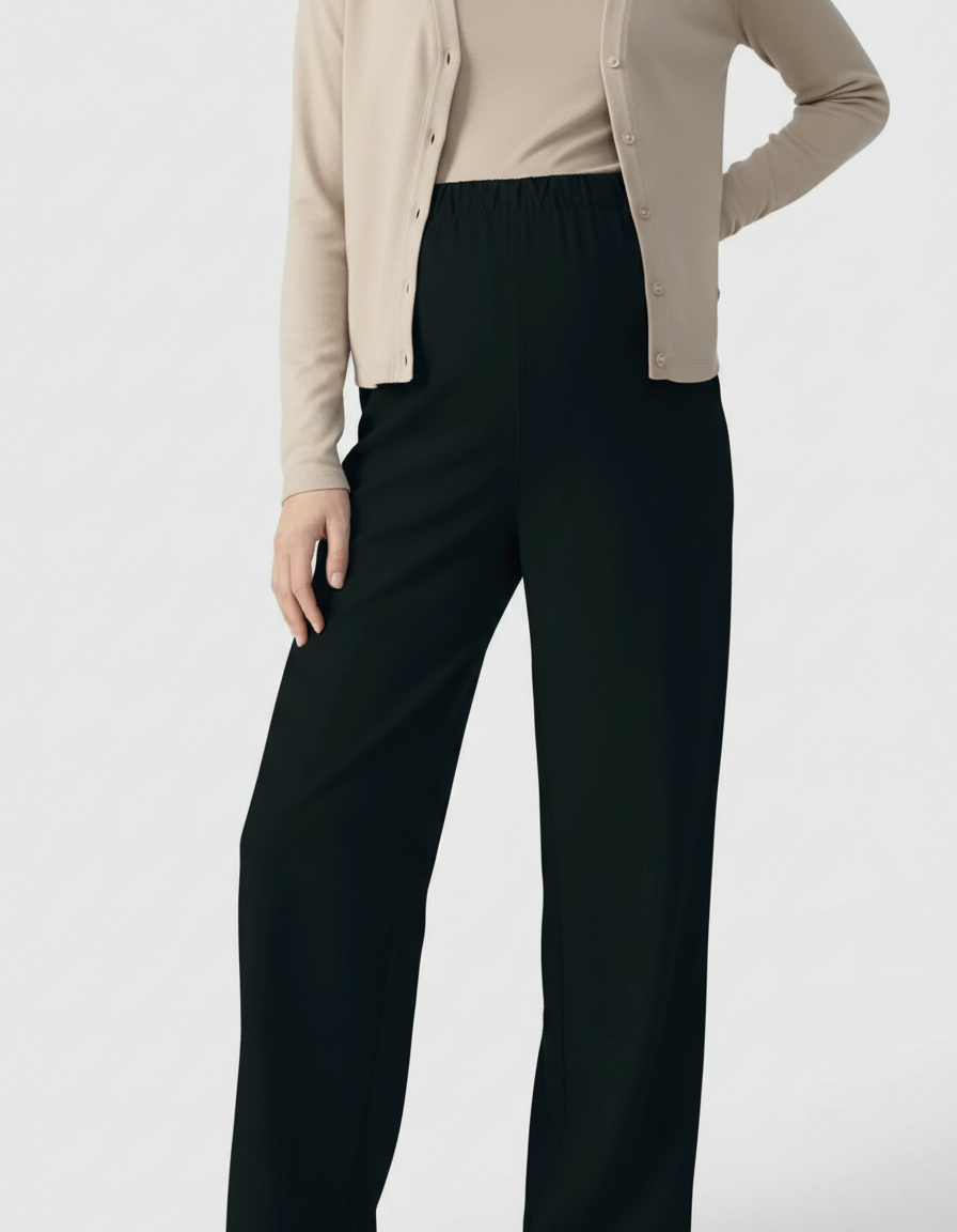 Woman wearing black wide-leg maternity pants with an adjustable elastic waist and a beige cardigan.
