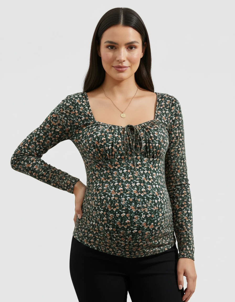 Pregnant woman in a dark green floral ruched tie-front maternity top with long sleeves.