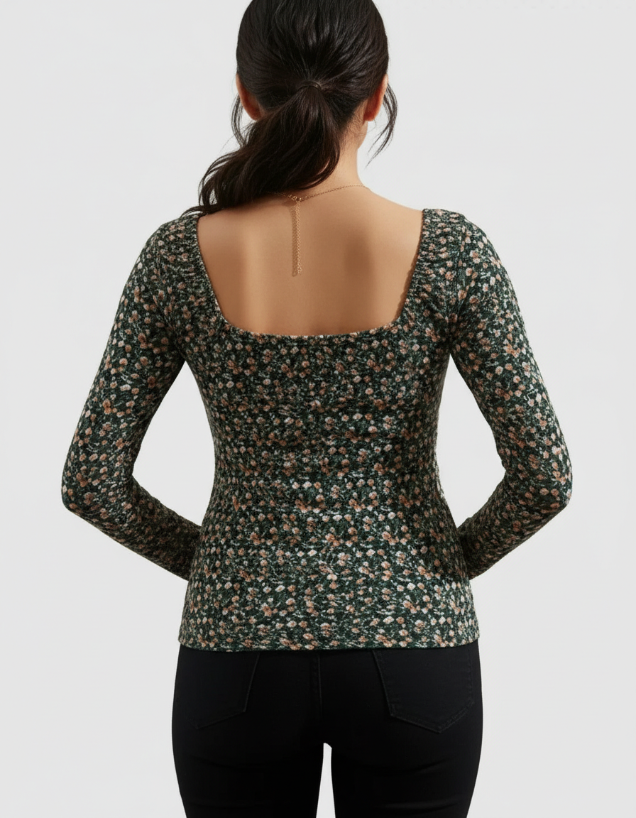 Woman from behind wearing a dark green floral long-sleeve maternity top with a square neckline.