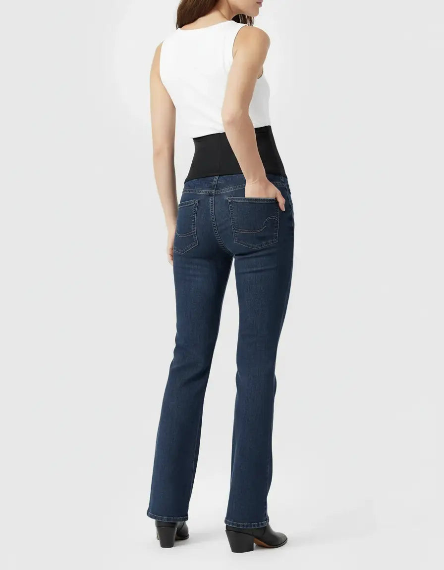 Dark wash, high-waist flared-leg maternity jeans with a black over-belly panel, worn by a woman.