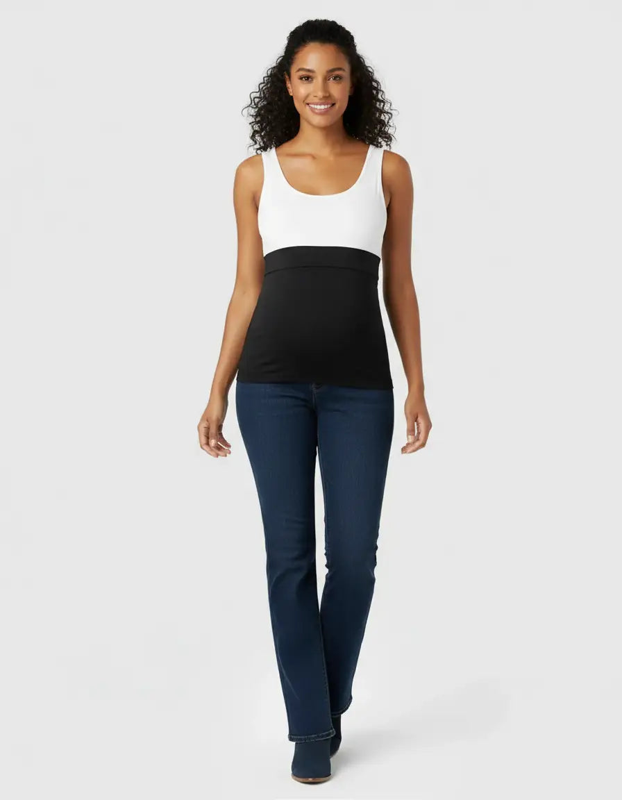 Smiling pregnant woman wearing dark wash, high-waist flared maternity jeans with a black over-belly panel.