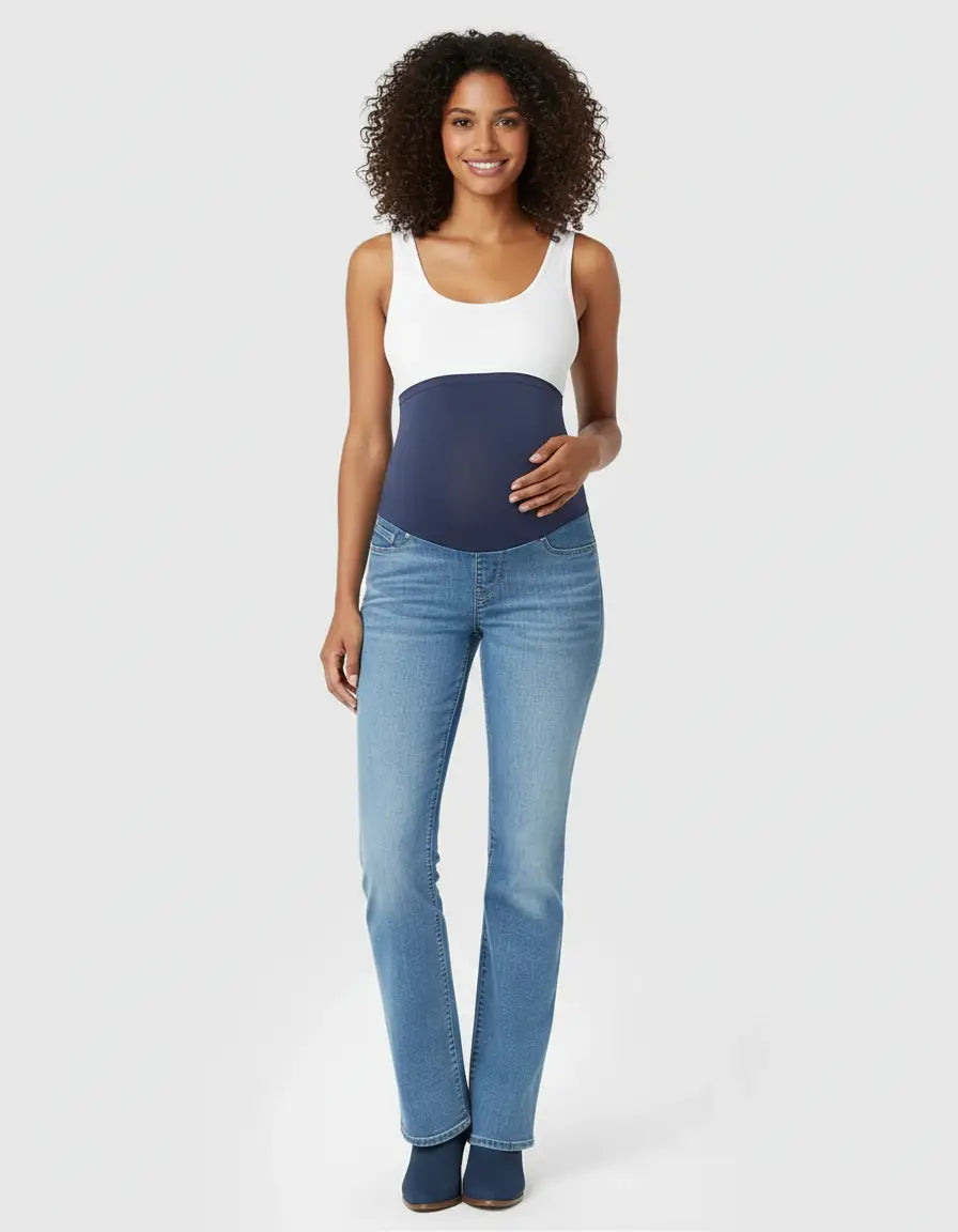 Smiling pregnant woman wearing light wash, high-waist, flared-leg maternity jeans with an over-belly panel.
