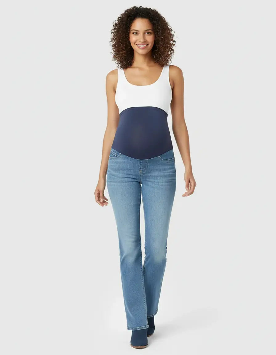 Smiling pregnant woman in light wash, high-waist flared-leg maternity jeans with a navy over-belly panel.