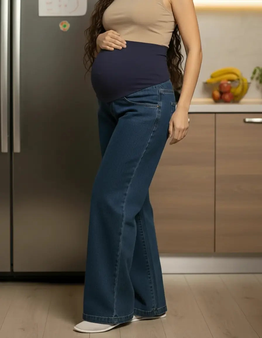 Pregnant woman in dark wash wide-leg maternity jeans with a navy elastic waist panel.