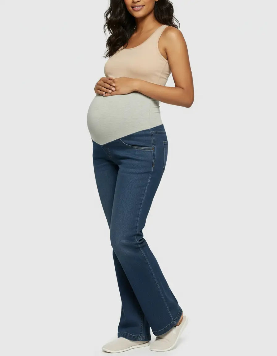 Maternity model in dark wash wide-leg jeans with a light grey elastic belly band and a beige tank top.
