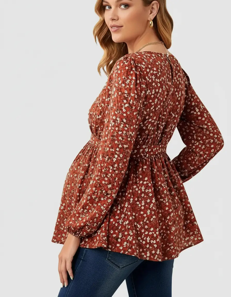 Maternity top: rust floral print, long sleeves, tie waist, peplum hem, worn by pregnant woman.