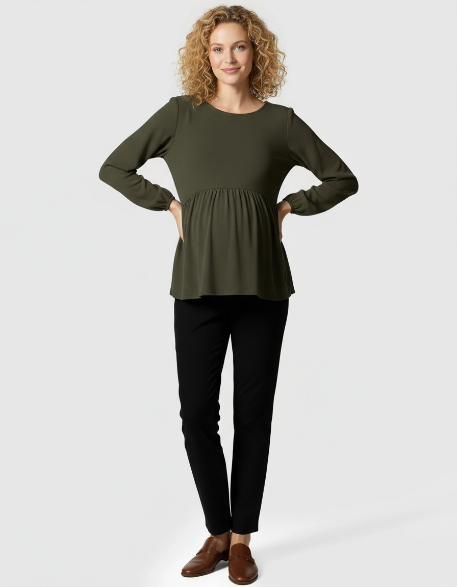 Smiling pregnant woman in a dark green long-sleeve maternity top and black kick flare pants.