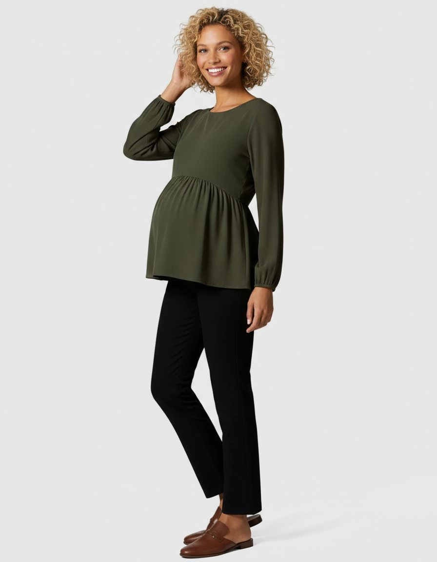 Smiling pregnant woman in an olive green long-sleeve peplum top and black maternity pants.