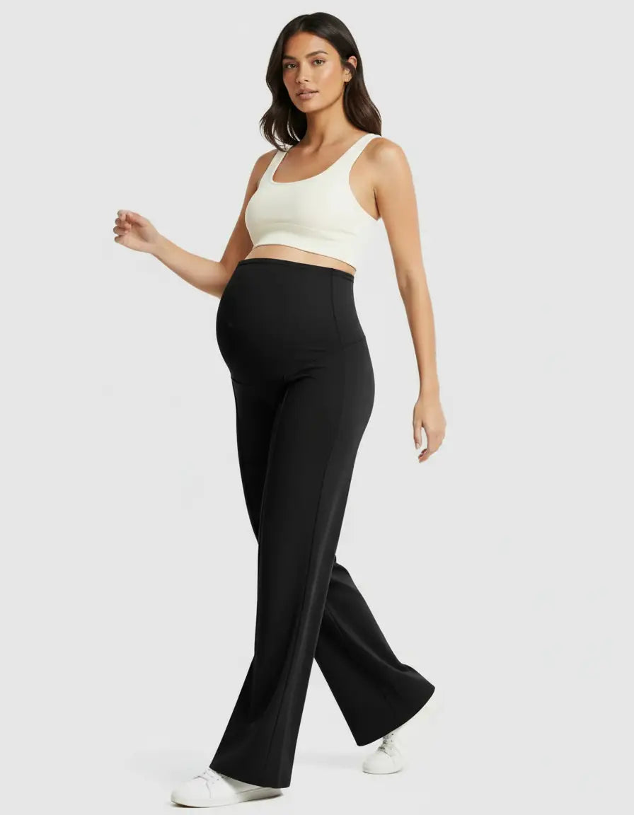 Pregnant woman in black high-waist maternity pants with a relaxed fit and a white crop top.