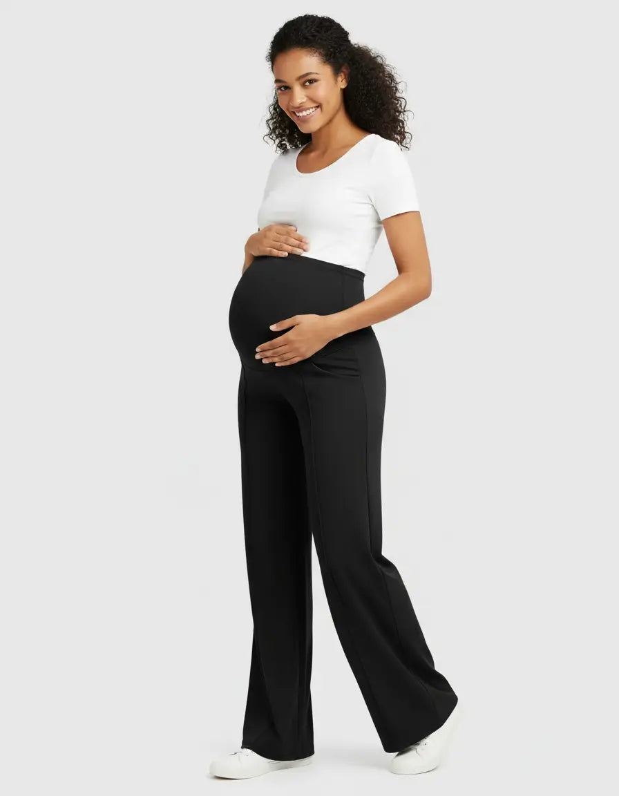 Smiling pregnant woman wearing black high-waist maternity pants with a relaxed fit and a white t-shirt.
