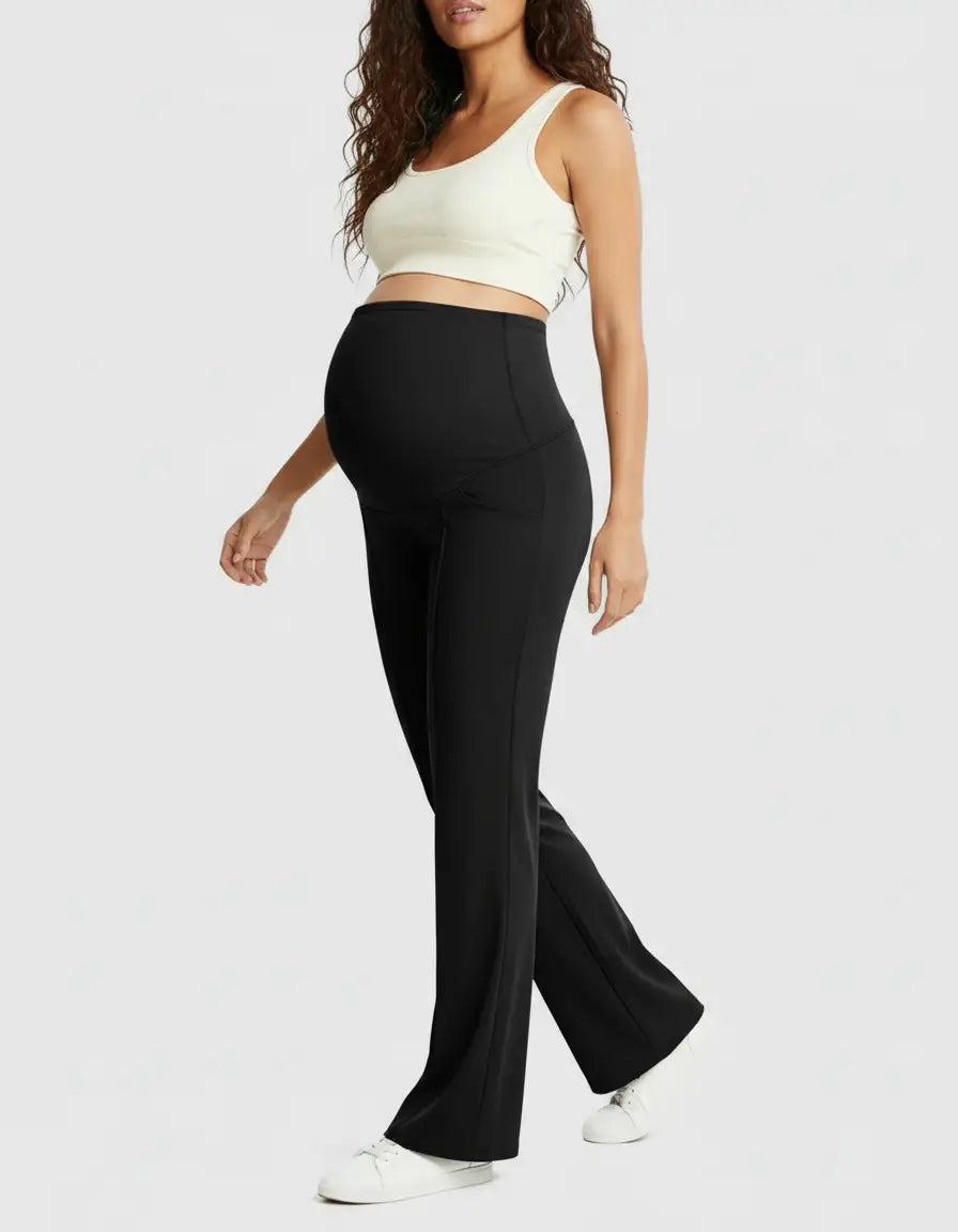 Woman in black high-waist maternity pants with a relaxed fit and a white crop top.