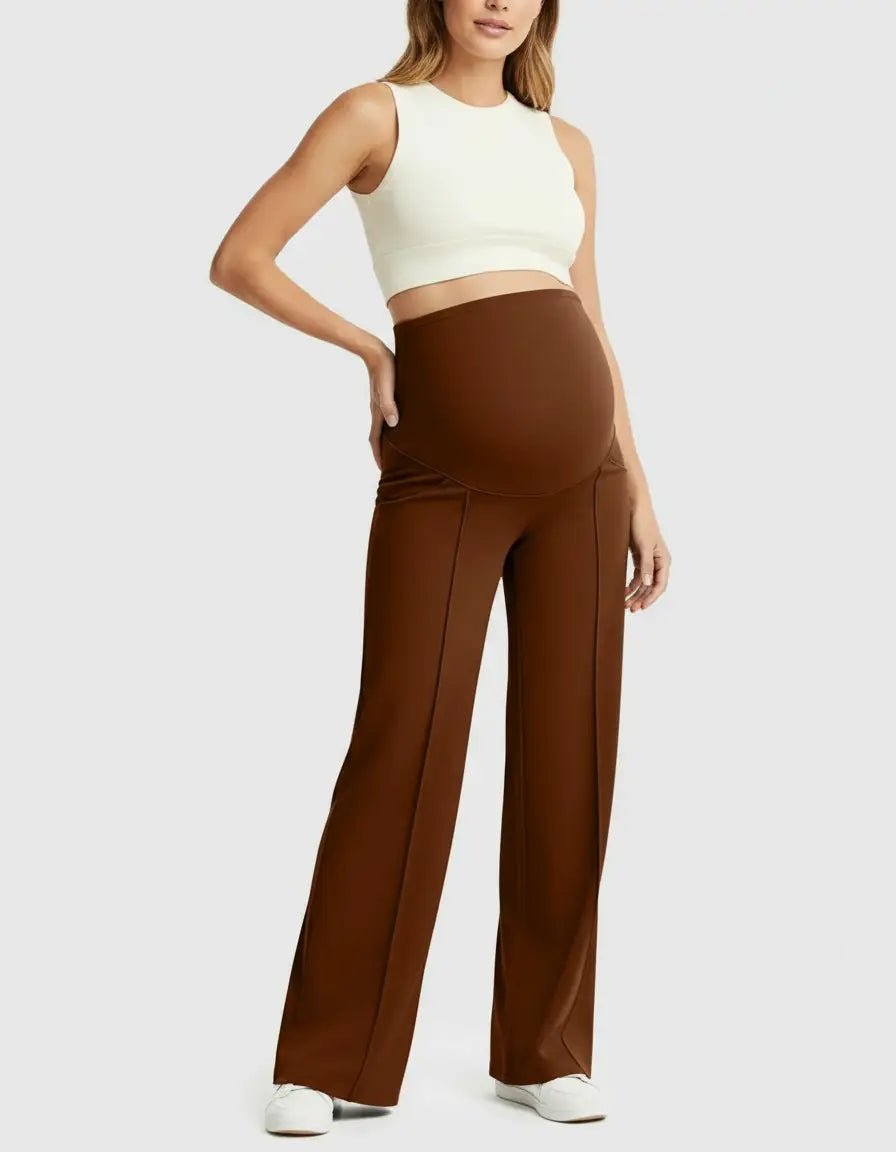 Woman in brown high-waist maternity pants with a relaxed fit and a white crop top.