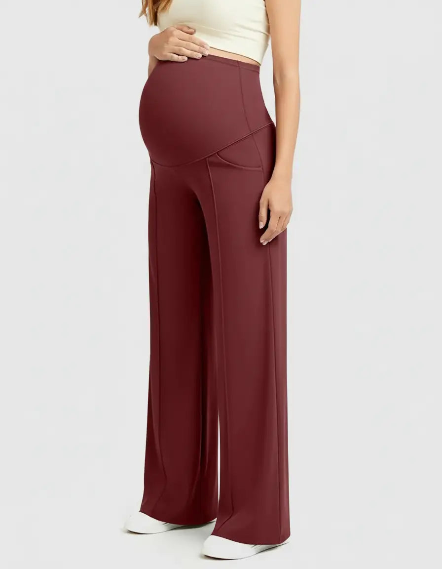 Woman wearing high-waisted, relaxed-fit burgundy maternity pants with a supportive belly panel.