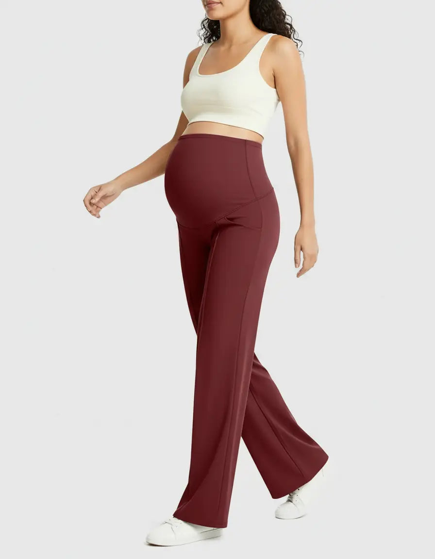 Pregnant woman in high-waist, relaxed-fit burgundy maternity pants and a white crop top.