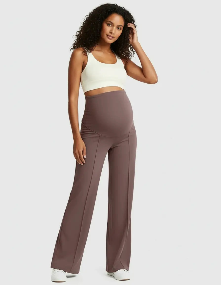 Woman in high-waist, relaxed-fit brown maternity pants with a cream crop top.