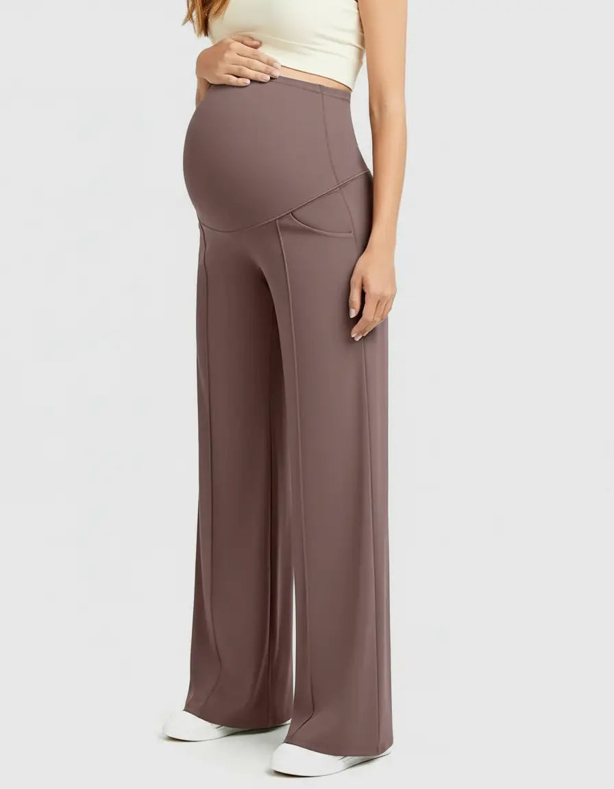 Maternity model wearing high-waist, relaxed-fit brown pants with a supportive belly panel and wide legs.