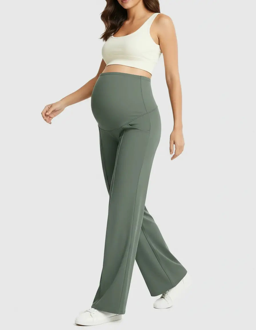 Pregnant woman in olive green high-waist maternity pants with a relaxed fit and a white crop top.