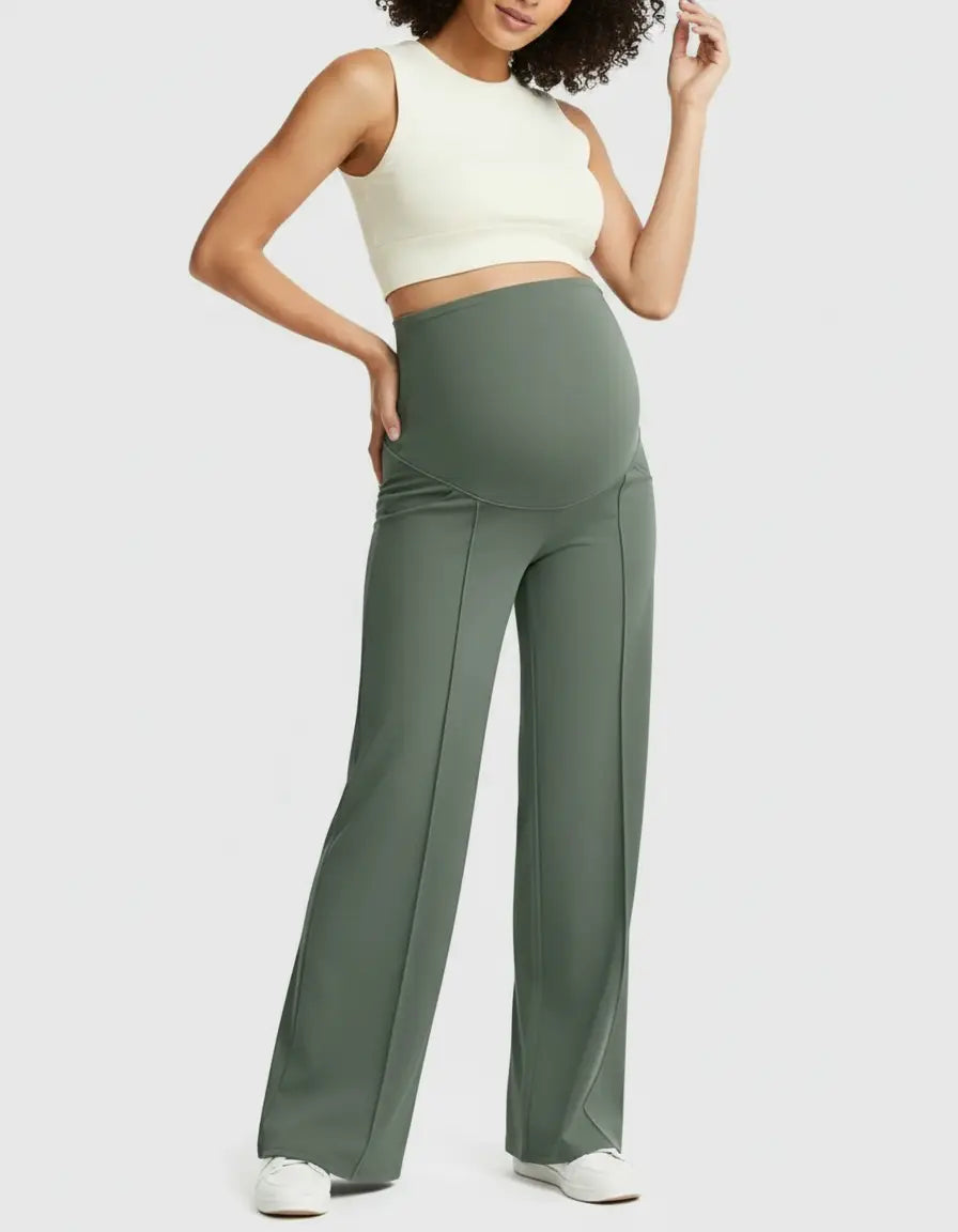 Woman wearing olive green high-waist maternity pants with a relaxed fit and a cream crop top.