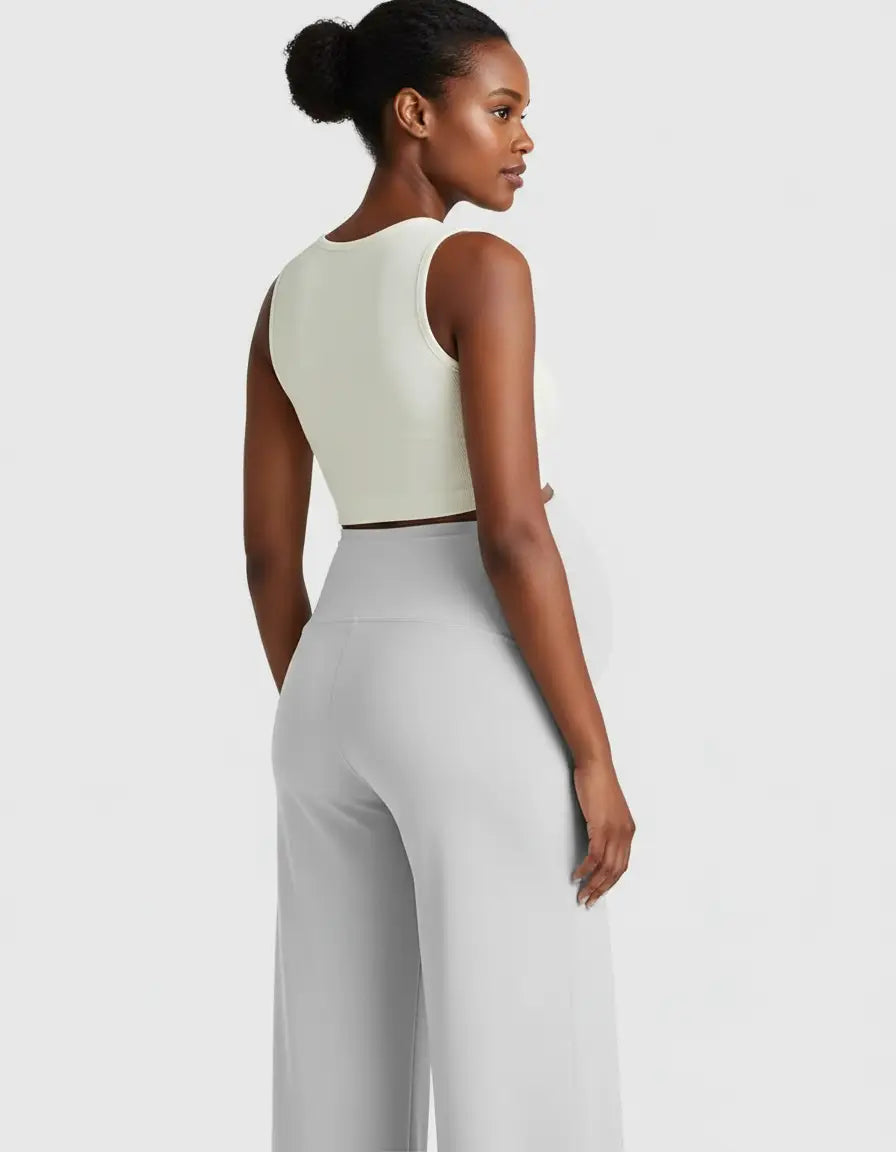 Pregnant model in light gray high-waist maternity pants with a relaxed fit and a cream crop top.