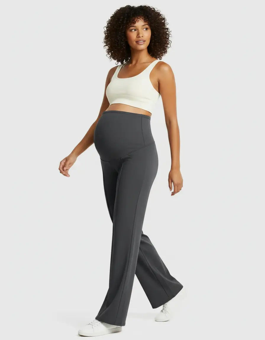 Pregnant woman in charcoal high-waist maternity pants with a relaxed fit and a white crop top.