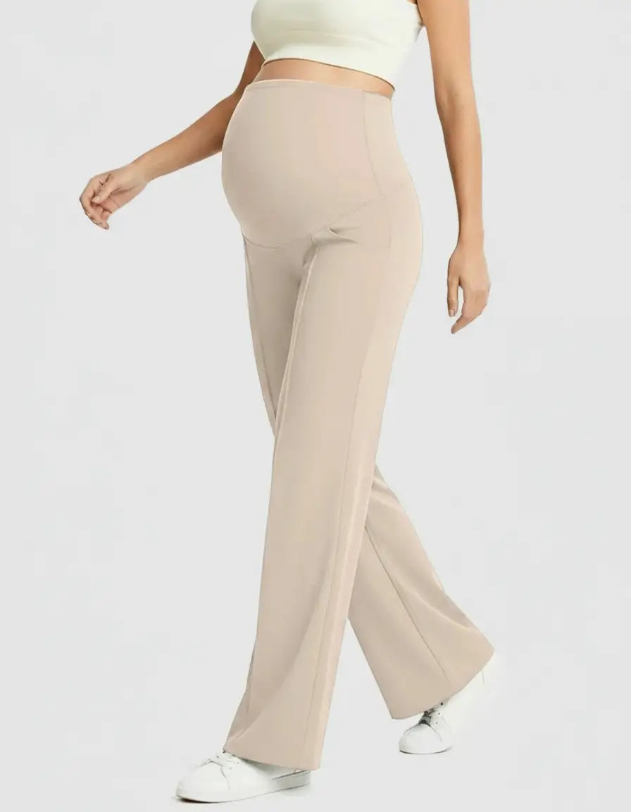 Pregnant woman in beige high-waist maternity pants with a relaxed, wide-leg fit and a supportive belly panel.