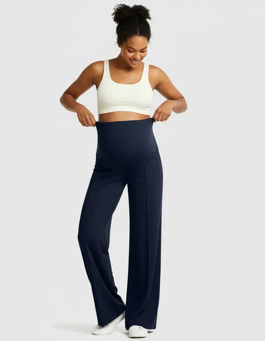 Smiling pregnant woman in navy high-waist maternity pants with a relaxed, wide-leg fit and a white crop top.