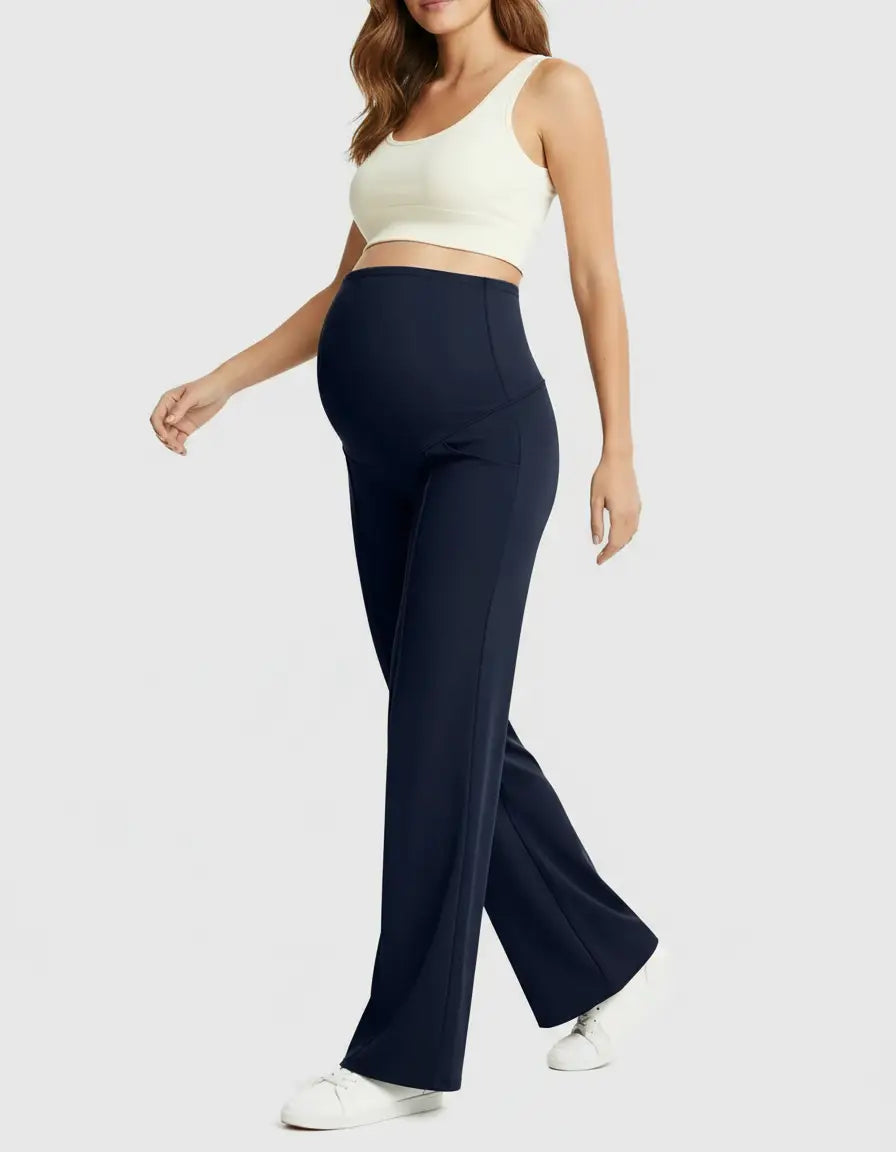 Woman in navy high-waist maternity pants with a relaxed fit and a white crop top.