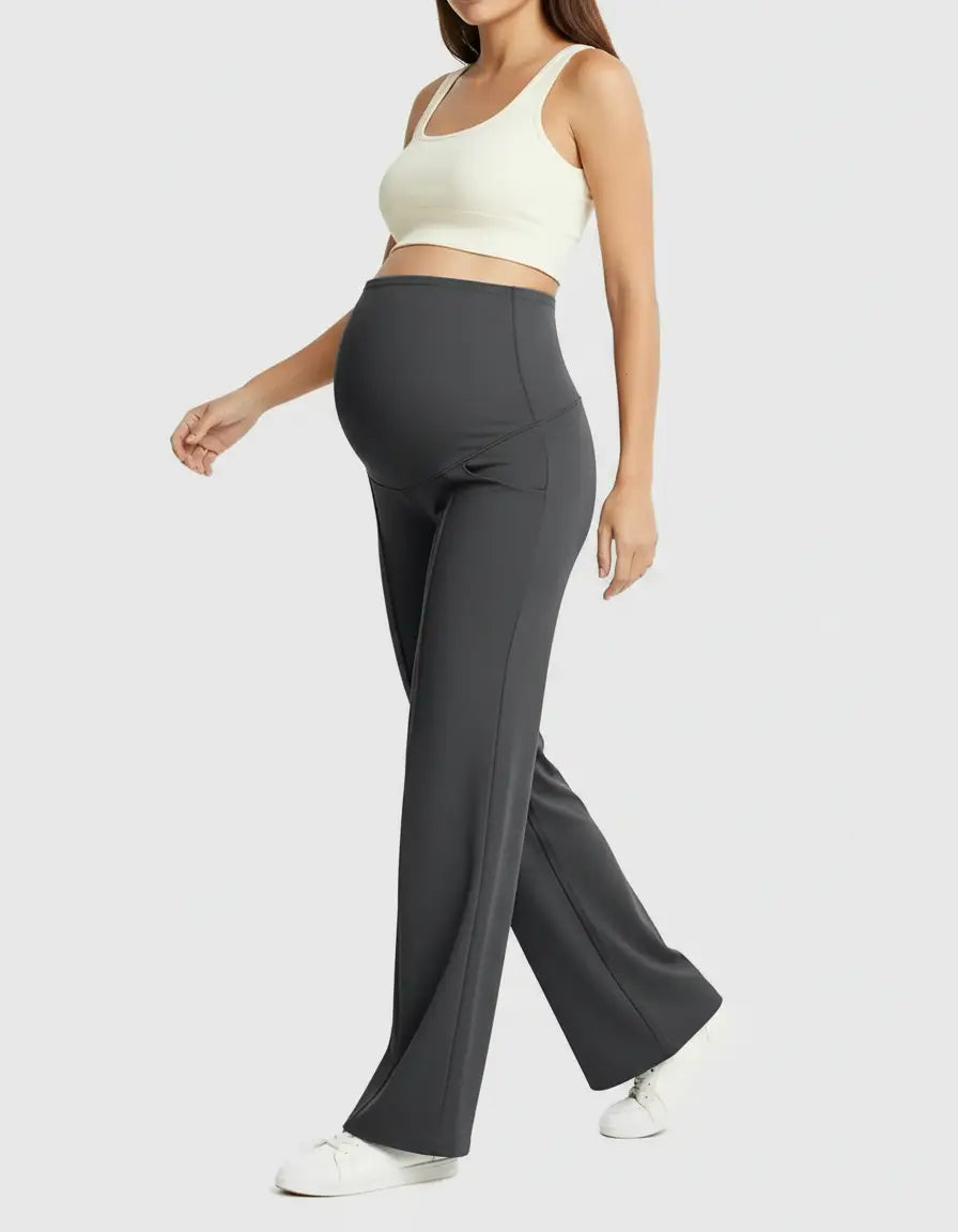 Woman wearing dark gray high-waist maternity pants with a relaxed, wide-leg fit and a white crop top.