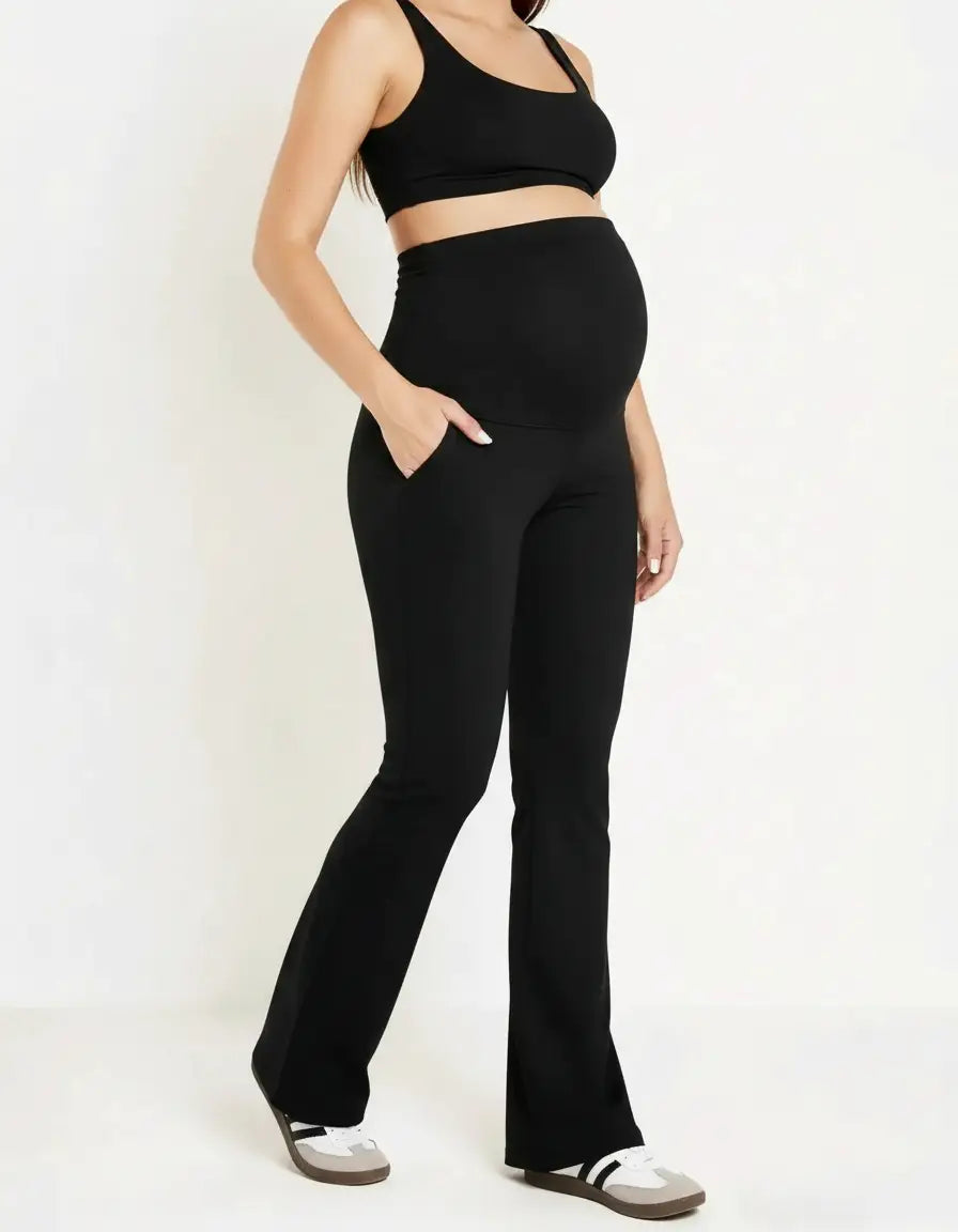 Black high-waist pocketed flare-leg maternity leggings on a pregnant model.