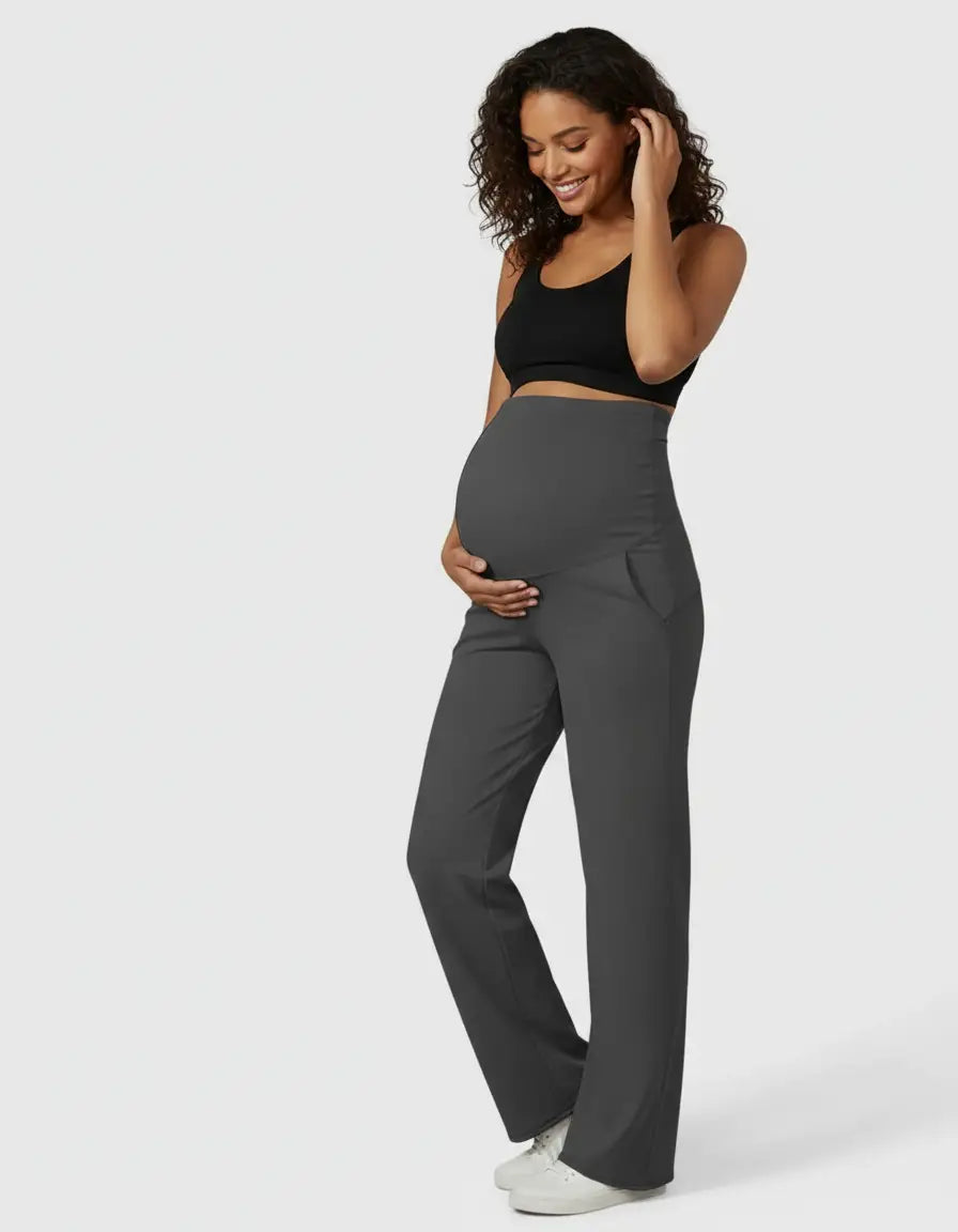 Smiling pregnant woman in charcoal high-waist straight-leg maternity pants and a black bra.