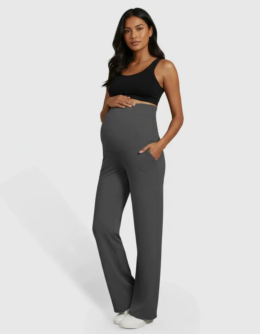 Pregnant woman in charcoal gray high-waist straight-leg maternity pants with pockets and a black bra.