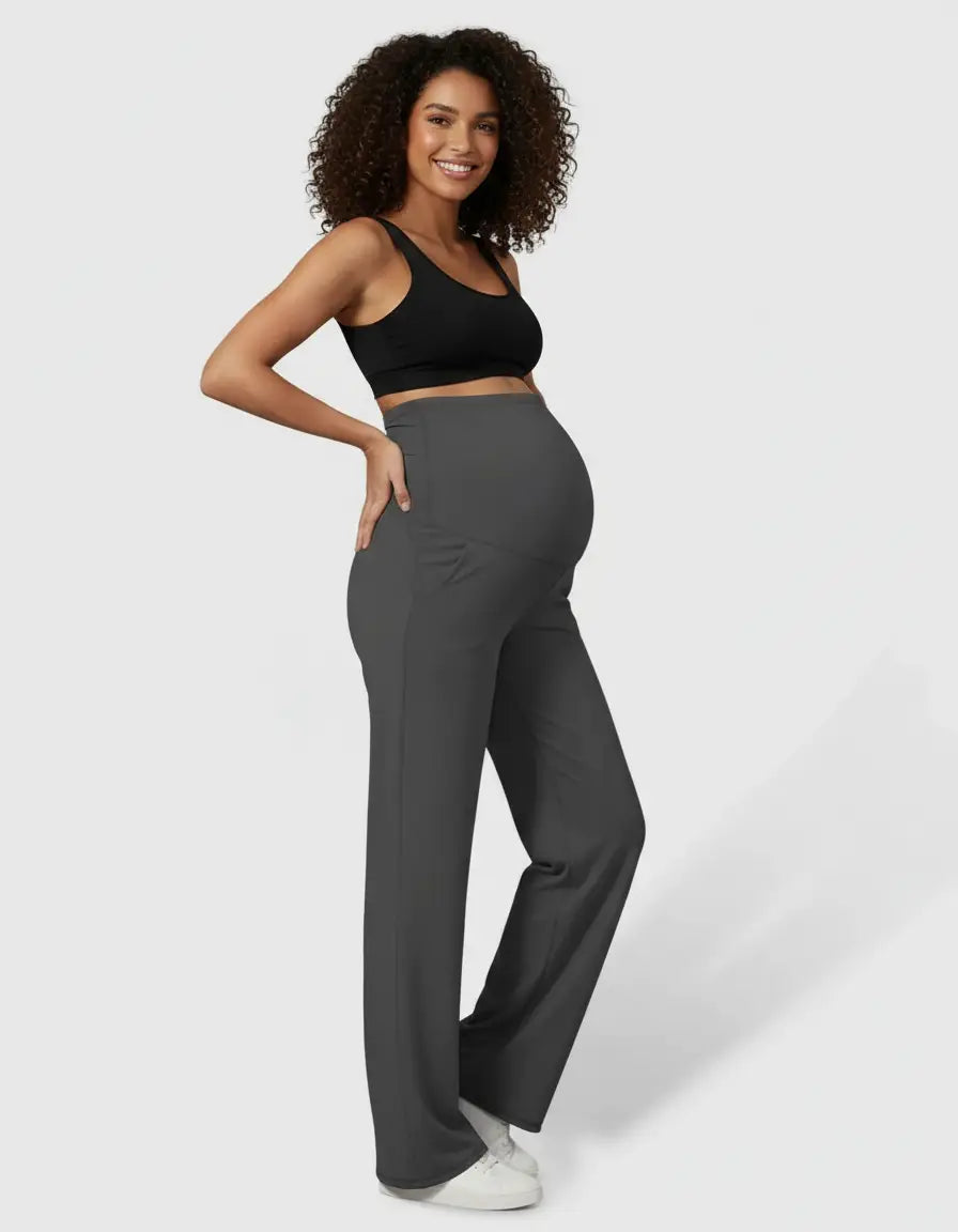 Smiling pregnant woman in charcoal high-waist straight-leg maternity pants and a black bra.